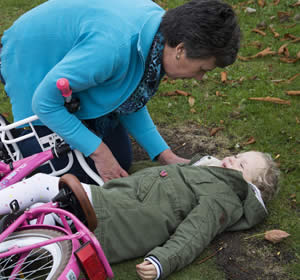 Woman attending to injured small child lying on the ground